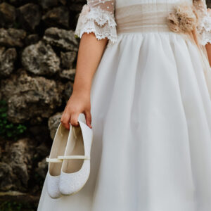 communion-girl-with-white-dress-holding-white-shoe-2022-12-31-04-44-52-utc